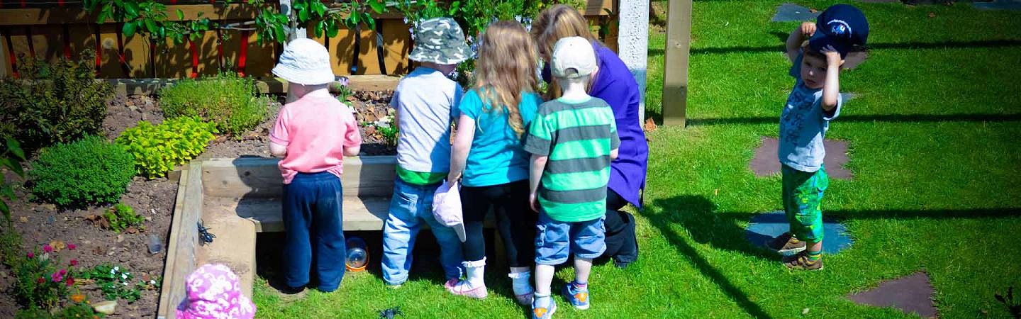Photo: children learning outdoors at Kiddlywinks Nursery, Penrith